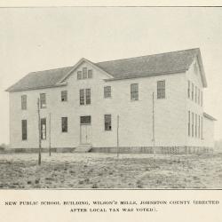Two-story wooden school house in open field