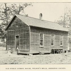 Old school house with two children outside of front door