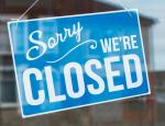 Light blue sorry we're closed sign hanging on window
