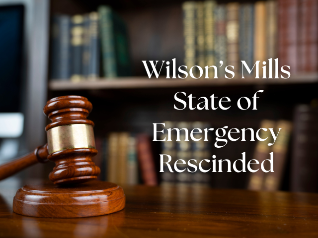 Gavel on desk in front of law books on bookshelf